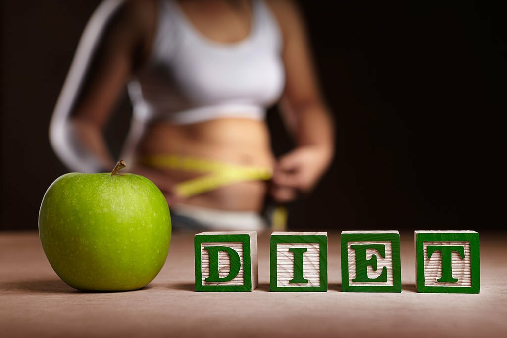 Word 'DIET' with apple, measuring tape and woman body